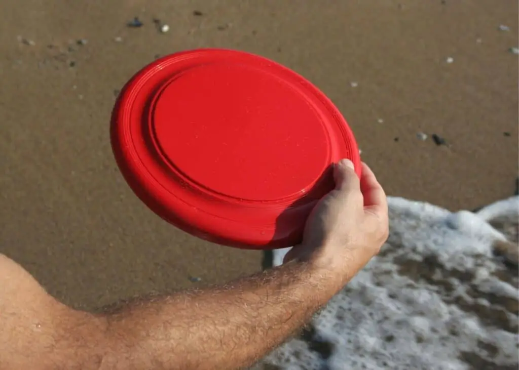 Man with wrist curl when throwing a disc.